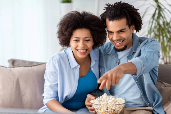 Usmívající se pár s popcorn sledování televize u vás doma — Stock fotografie