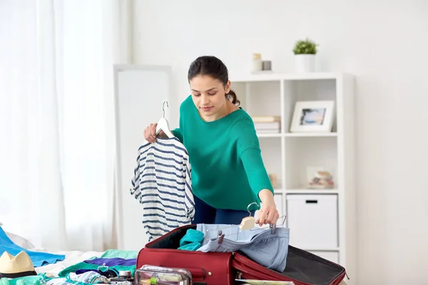 Woman packing travel bag at home or hotel room — Stock Photo, Image