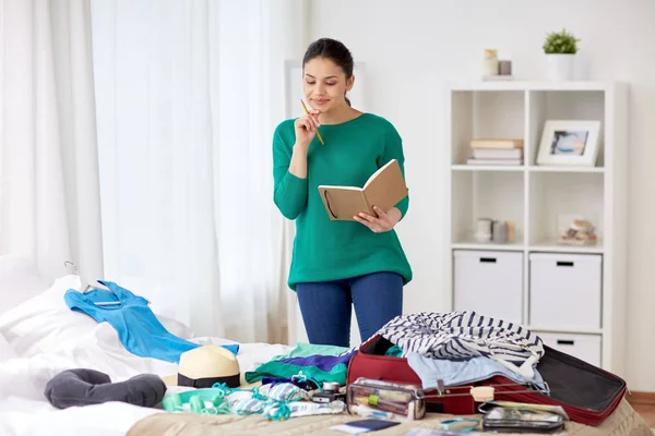 Woman with notebook planning her trip at home — Stock Photo, Image