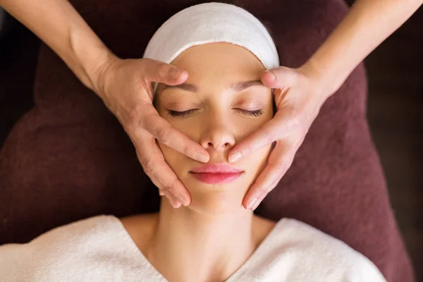 Frau mit Gesichts- und Kopfmassage im Wellnessbereich — Stockfoto