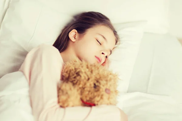 Dívka s hračka medvídek v posteli doma — Stock fotografie