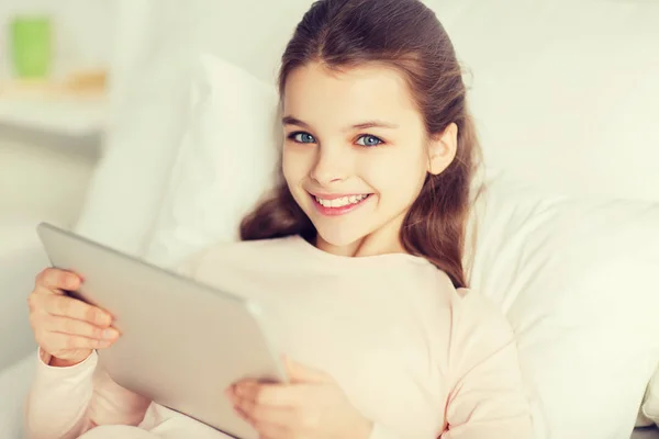 Chica feliz acostada en la cama con la tableta PC en casa — Foto de Stock