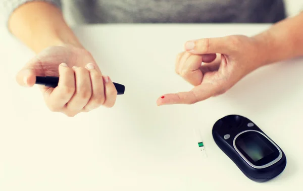 Close up van de vrouw bloedonderzoek door glucometer maken — Stockfoto