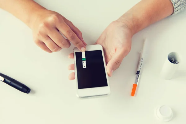 Close up van vrouw met smartphone bloedonderzoek doen — Stockfoto