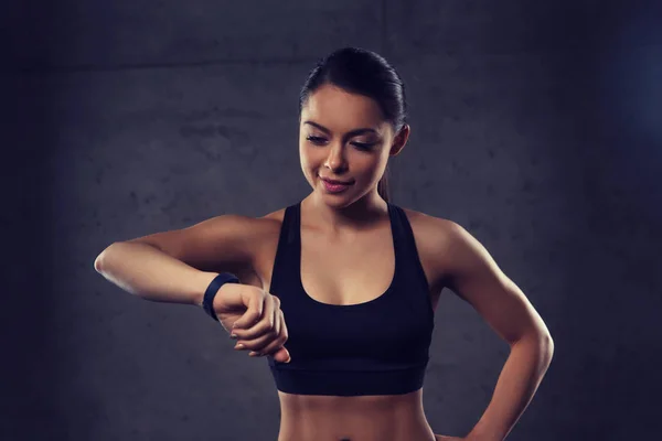 Giovane donna con cardiofrequenzimetro in palestra — Foto Stock