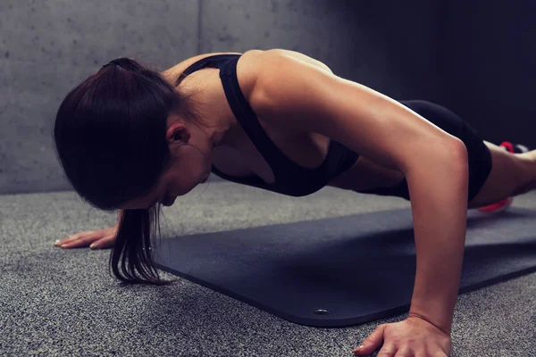 Kvinnan gör armhävningar i gym — Stockfoto