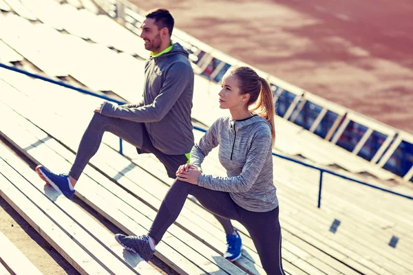 Para stretching nóg na trybunach stadionu — Zdjęcie stockowe