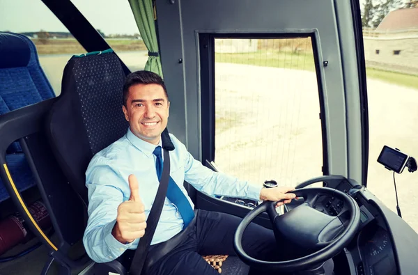 Счастливый водитель за рулем автобуса и заснеженные тумбы — стоковое фото