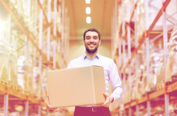 Homem feliz com caixa de papelão pacote no armazém — Fotografia de Stock