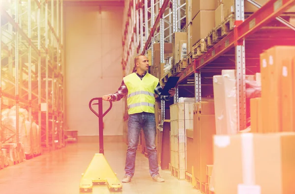 Man with loader and clipboard at warehouse — Stock Photo, Image