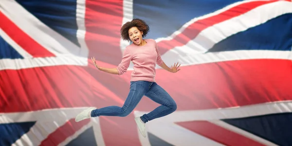 Donna afroamericana che salta sopra la bandiera inglese — Foto Stock