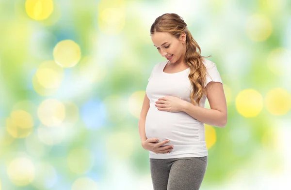Щаслива вагітна жінка торкається її великого живота — стокове фото