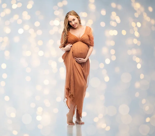 Mulher grávida feliz tocando sua barriga grande — Fotografia de Stock