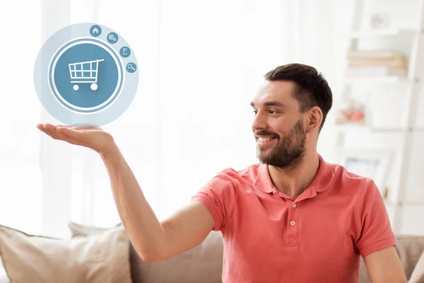 Man with shopping cart icon projection at home — Stock Photo, Image