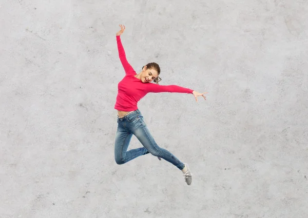 Счастливая молодая женщина прыгает в воздух или танцует — стоковое фото
