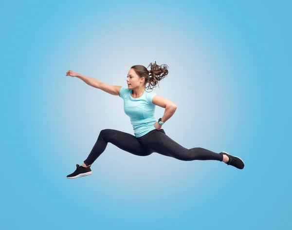 Gelukkig sportieve jonge vrouw springen in de strijd tegen pose — Stockfoto