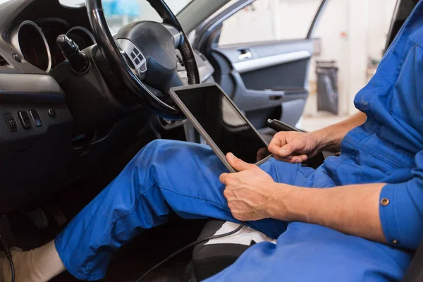Mechanic man with tablet pc making car diagnostic — стоковое фото