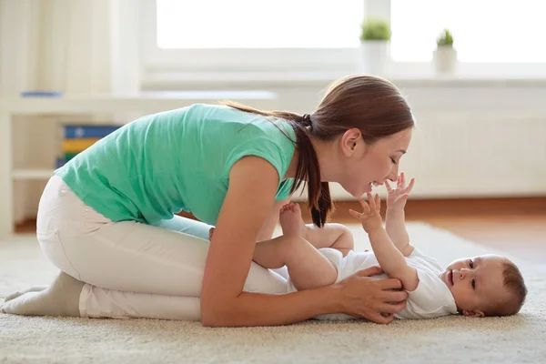 Feliz madre jugando con el bebé en casa — Foto de Stock