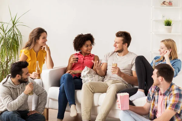 Amigos felizes com pipocas e cerveja em casa — Fotografia de Stock