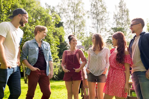 Happy teenage friends talking at summer garden — Stock Photo, Image