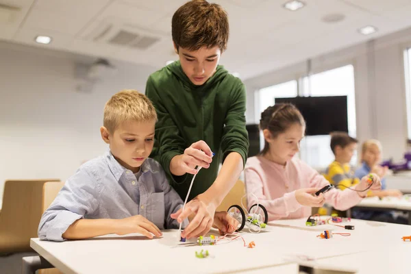 Gelukkige kinderen bouwen robots op robotica school — Stockfoto