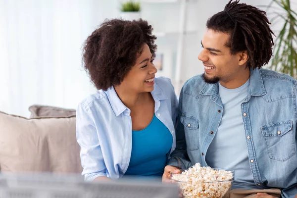 Усміхнена пара з попкорном дивитися телевізор вдома — стокове фото