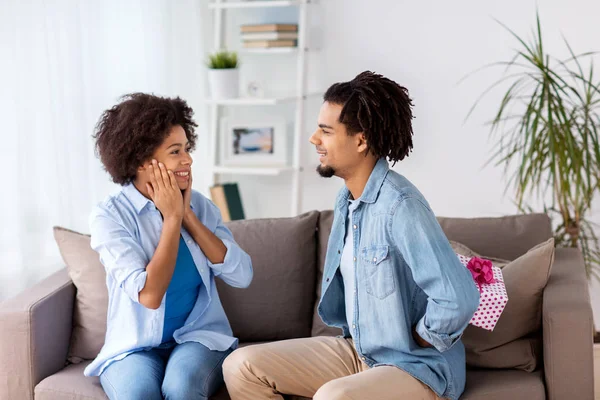 Feliz pareja con caja de regalo en casa — Foto de Stock