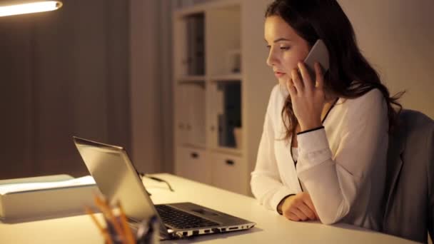 Женщина с ноутбуком звонит на смартфон в офисе — стоковое видео