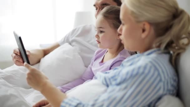 Família feliz com tablet pc na cama em casa — Vídeo de Stock