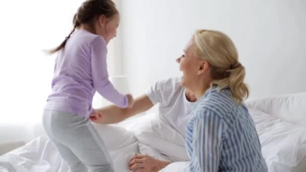 Familia feliz divirtiéndose en la cama en casa — Vídeos de Stock