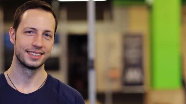 Щасливий усміхнений молодий чоловік у спортзалі — стокове відео