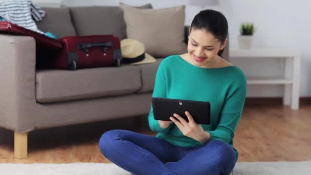 Kvinna med TabletPC förbereda för resor hemma — Stockvideo