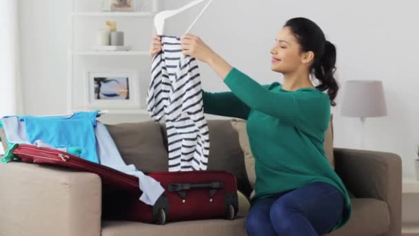Donna che confeziona vestiti per viaggiare borsa a casa — Video Stock