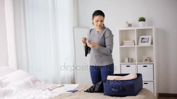 Женщина упаковывает дорожную сумку дома или в гостиничном номере — стоковое видео