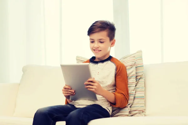 Lachende jongen met tablet pc thuis — Stockfoto