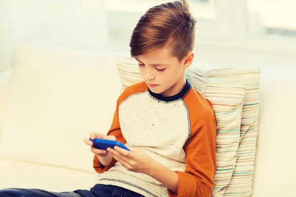 Menino com mensagens de texto smartphone ou jogar em casa — Fotografia de Stock
