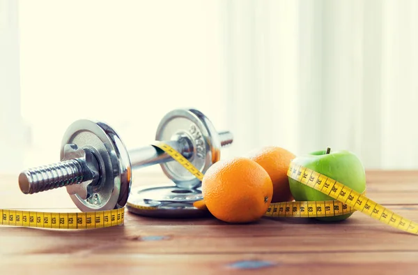 Close up of dumbbell, fruits and measuring tape — Stock Photo, Image