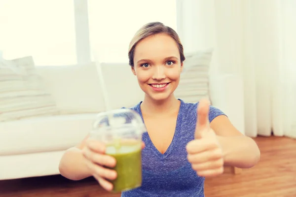 Mujer feliz con taza de batido mostrando los pulgares hacia arriba — Foto de Stock