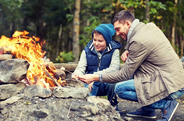 Pai e filho assar marshmallow sobre fogueira — Fotografia de Stock