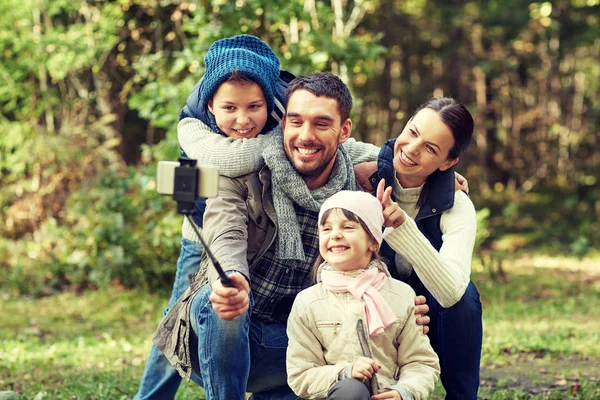 Família feliz com vara selfie smartphone na floresta — Fotografia de Stock