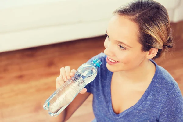 Mujer feliz con botella de agua en casa — Foto de Stock