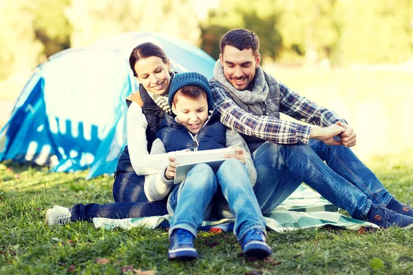 Famiglia felice con tablet pc e tenda nel campeggio — Foto Stock