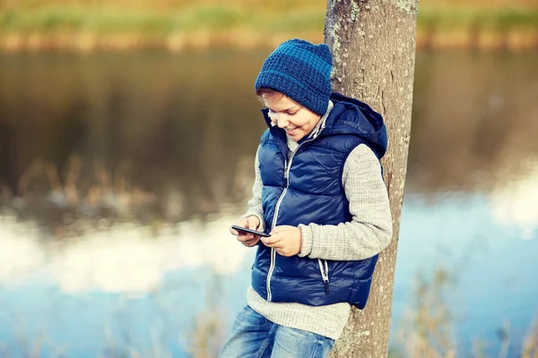 Glücklicher Junge spielt Spiel auf Smartphone im Freien — Stockfoto