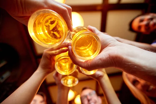 Amigos tintineo vasos de cerveza en el pub o bar —  Fotos de Stock