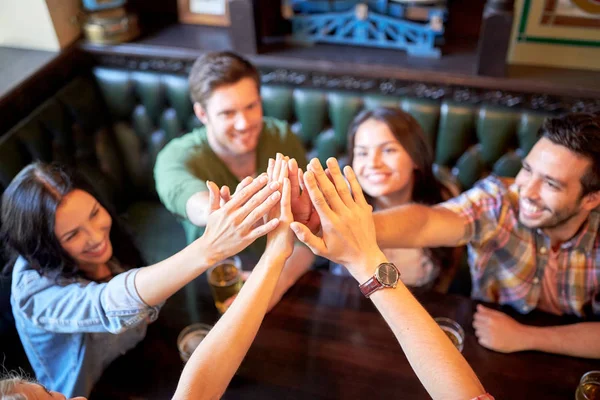 Vrienden drinken bier en het maken van hoge vijf op balk — Stockfoto