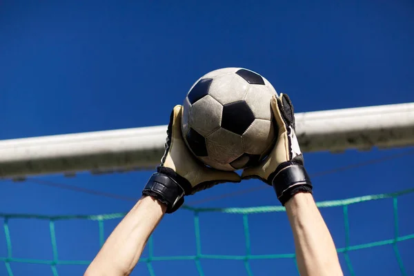 Воротар з м'ячем на футбольному полі над небом — стокове фото