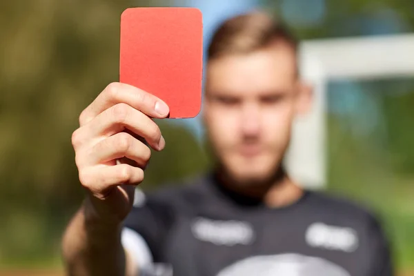 Mãos árbitro com cartão vermelho no campo de futebol — Fotografia de Stock