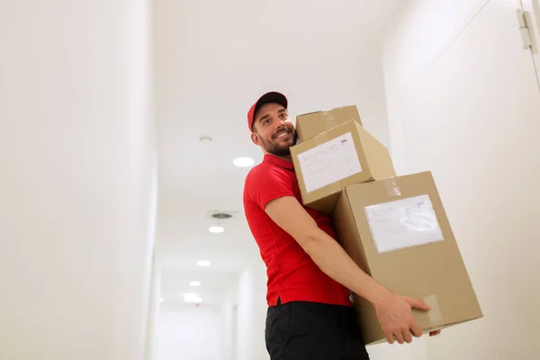 Repartidor con cajas de paquetes en pasillo — Foto de Stock