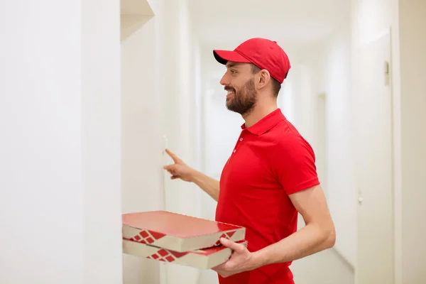 Entregador com caixas de pizza tocando campainha — Fotografia de Stock