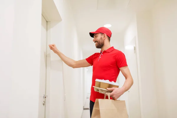 Repartidor con café y comida llamando a la puerta — Foto de Stock